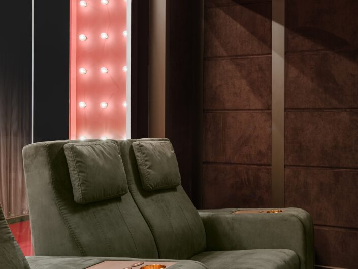 Cinema room in house with green comfortable chairs